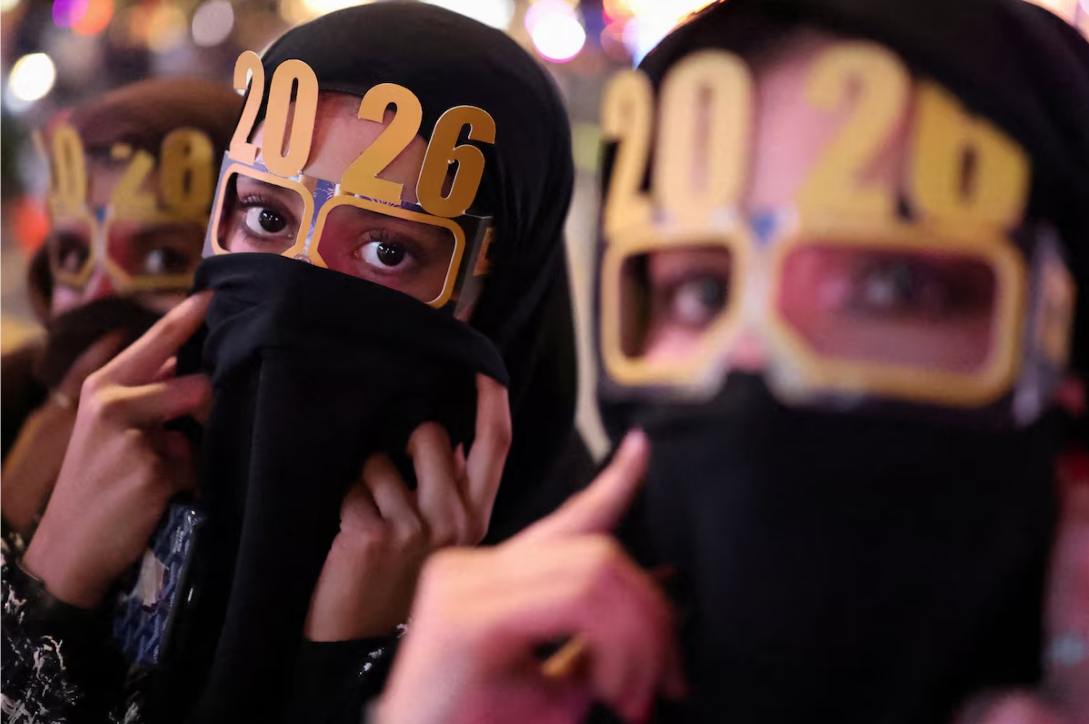 在卡塔尔卢赛尔，人们戴着印有“2026”字样的眼镜庆祝新年